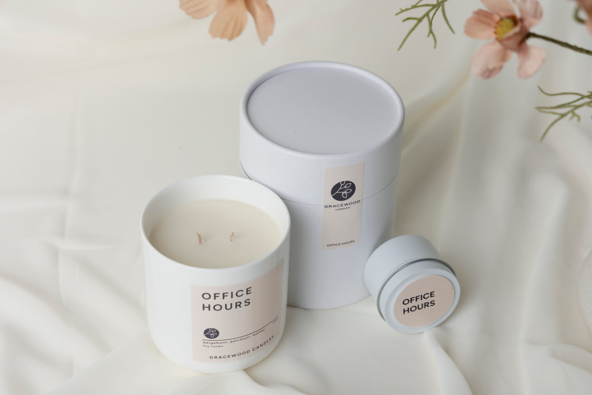 Two candles labeled 'Office Hours' on a white surface with floral elements.
