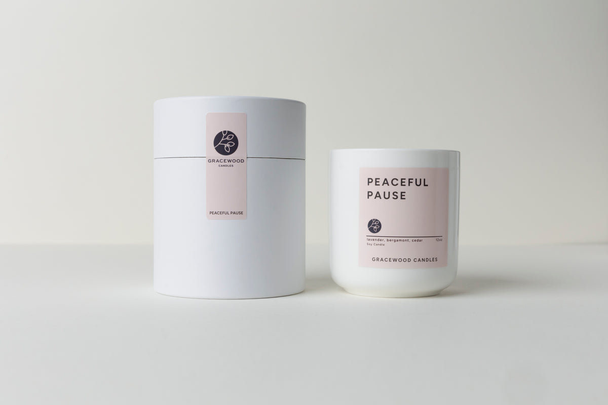 Two candles, one in a white container and the other with a label, on a light gray background.