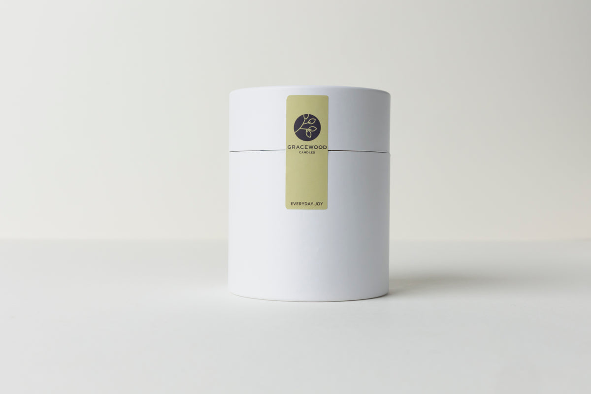 White cylindrical container with a gold label on a white background