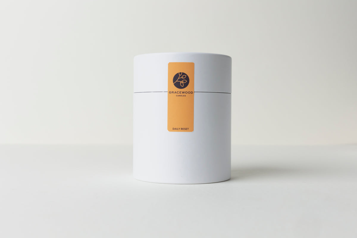 White cylindrical container with a gold label on a white background