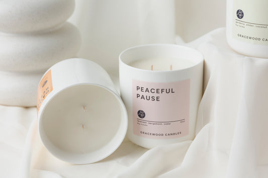 Candle labeled 'Peaceful Pause' from Gracewood Candles on a white fabric background