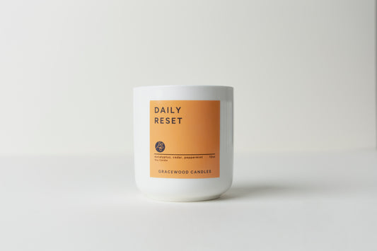 Candle with 'Daily Reset' label on a white background
