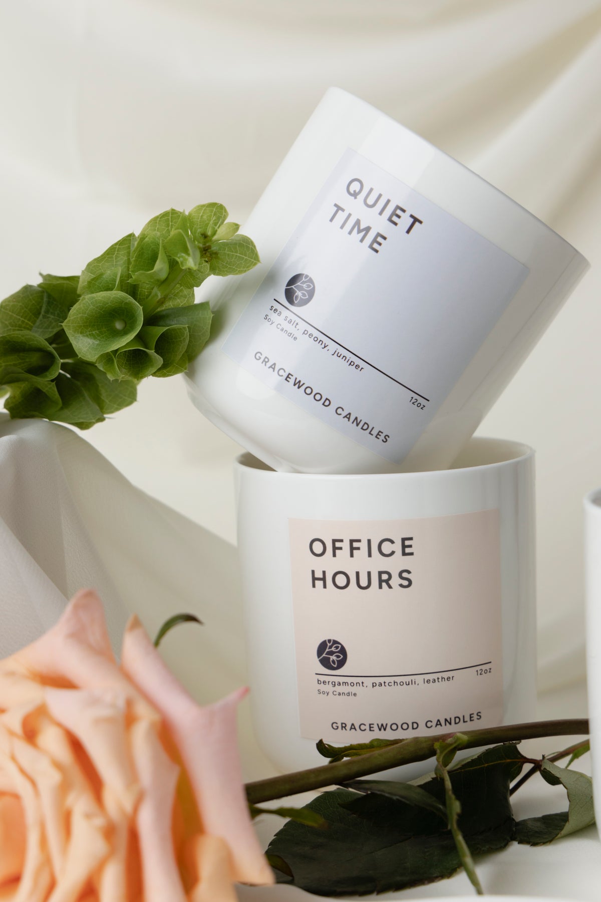 Two candles labeled 'Quiet Time' and 'Office Hours' by Gracewood Candles on a light background with greenery.