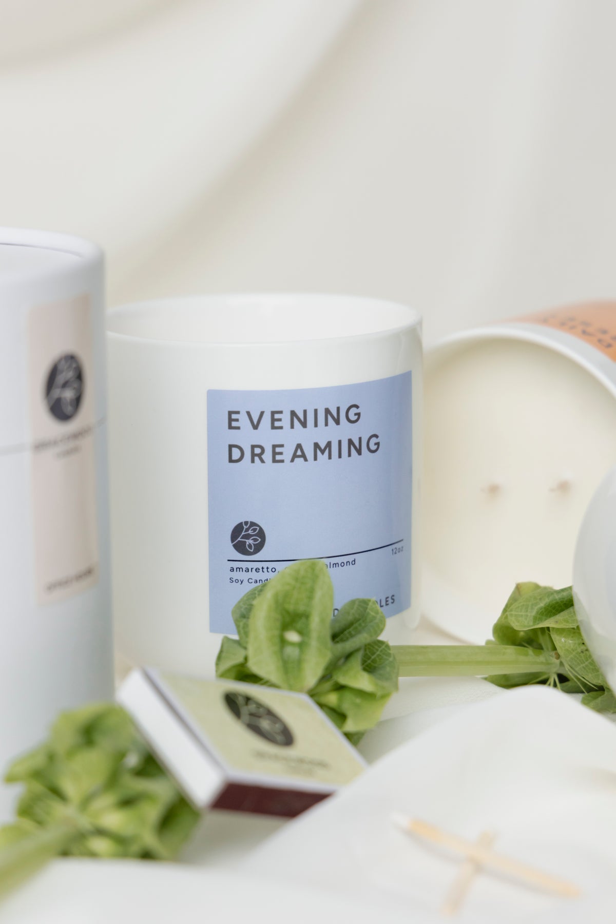 Candle container labeled 'Evening Dreaming' with green leaves on a white background